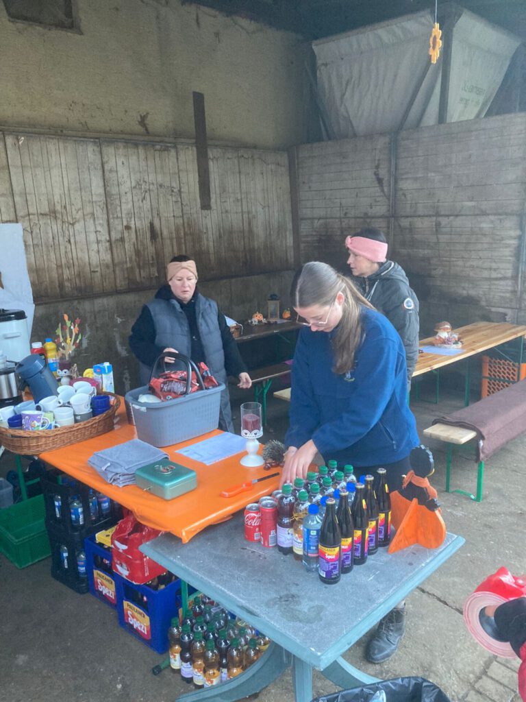 Leute, die bei einer Indoor-Veranstaltung einen Tisch mit Getränken und Snacks aufstellen.
